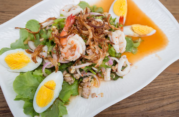 Thai style spicy salad on wood table.
