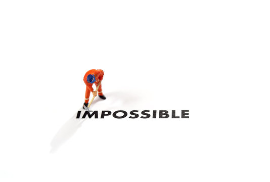 Worker digging with the text impossible, digging the word im so it written possible. success and challenge concept.