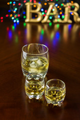 Two small glasses of whiskey and glass of whiskey with ice.