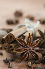 Spices for mulled wine. Cinnamon sticks, anise stars and cloves on wooden background.