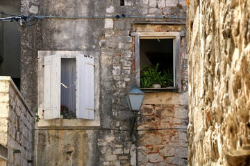 Picturesque windows and retro lamp on an old stone house in Trogir, Croatia. Trogir is popular touristic destination and UNESCO World Heritage Site.