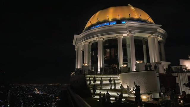 BANGKOK, THAILAND - NOVEMBER 02, 2015: Roman style illuminated dome and people walking in rooftop Sky Bar in five star Lebua Hotel at State Tower