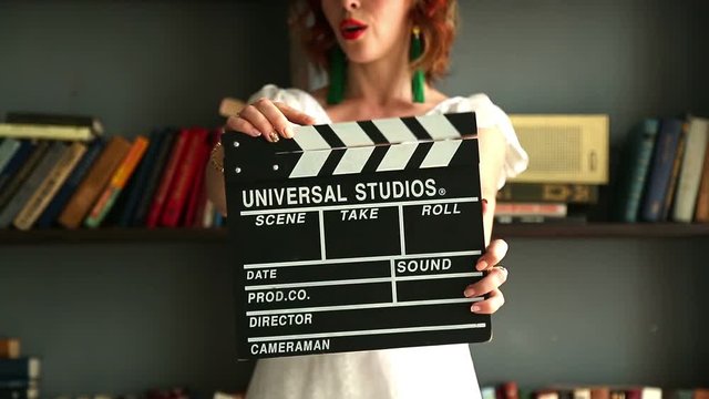 Beautiful girl with a clapperboard in the home.