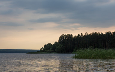 Colorful sunset on the lake. Summer evening by Sura reservoir, Russia.