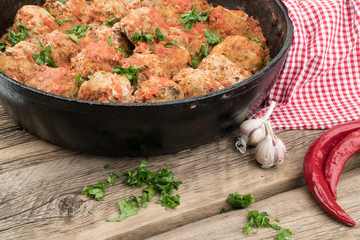 meat balls with herbs in pan on wooden rustic background.