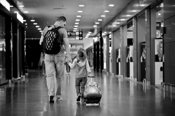 Father and daughter go through the airport