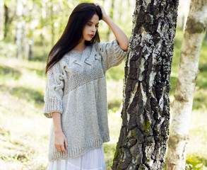 Woman in knitted pullover, meditating in the forest
