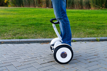 man rides on gyroscooter on the pavement in park.