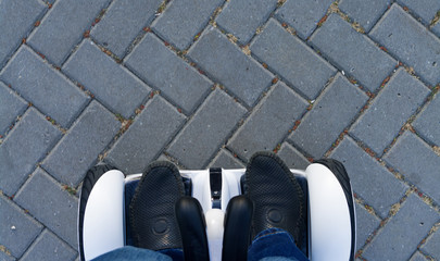 man rides on gyroscooter on the pavement in park.