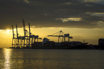 Cargo ship loaded in the shipping container terminal, Cargo container ship for shipping concept in sunset