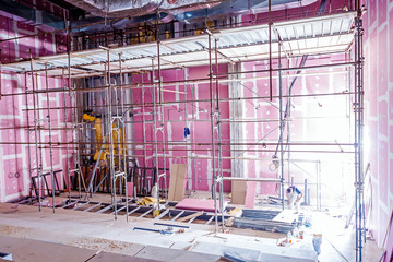 Scaffold in theater under construction with plasterboard walls,