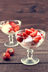 Ripe red strawberries and vanilla ice cream on rustic wooden bac