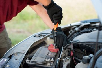 man repairing his car on the road