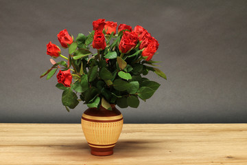 Vase of roses is on the table