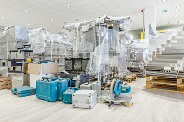 Plastic tool boxes on laminate floor in showroom with equipment