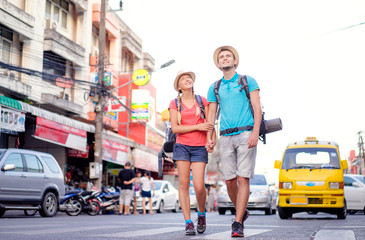 Travel and tourism. Couple of backpackers walking together on asian street.