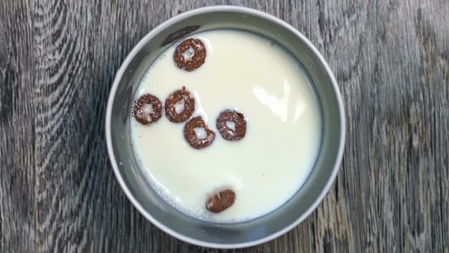 In a bowl with milk are strewed chocolate rings.