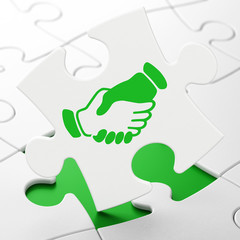 Business concept: Handshake on puzzle background