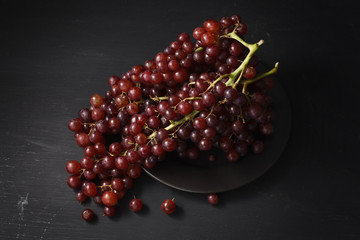 purple grapes still life on black background
