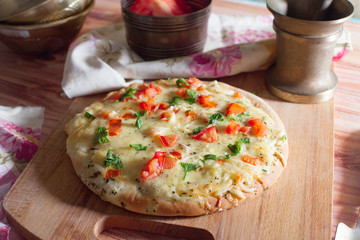 homemade pizza with a mini board tomatoes and herbs