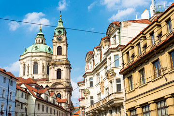 Fototapeta na wymiar St. Nicholas Church rising up between the narrow streets. Prague