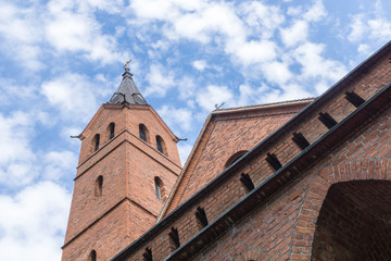 Fototapeta na wymiar Alte Kirche mit Backsteinwänden vor wolkigem Himmel