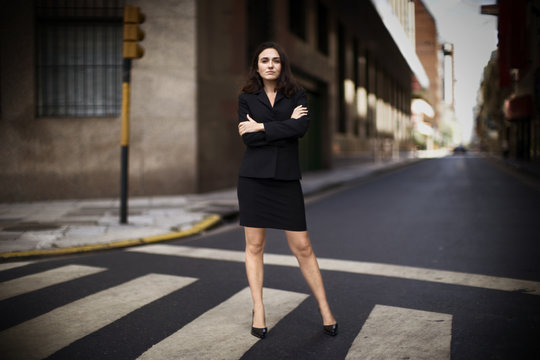 Portrait of an attractive woman posing on a roadway.