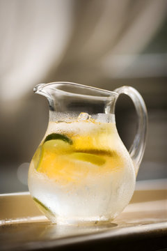 Close up of iced water in jug with citrus fruit slices