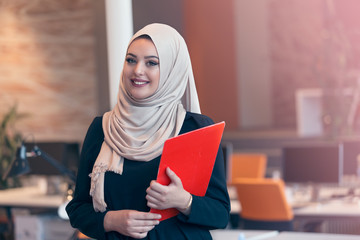 Arabian business woman holding a folder in modern startup office