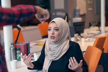 Worried arabic businesswoman wearing hijab receiving a notification from a colleague in her...