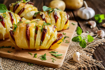 Baked potatoes stuffed with smoked sausage slices, cheese, garlic and herbs