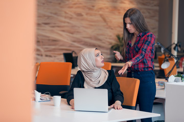 Worried arabic businesswoman wearing hijab receiving a notification from a colleague in her...
