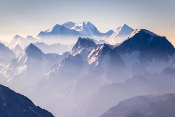 Poster Nevelige blauwe bergen bij zonsopgang © mzabarovsky