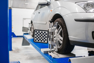 Car on stand with sensors wheels for alignment camber check in workshop of Service station.