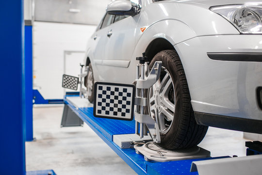 Car on stand with sensors wheels for alignment camber check in workshop of Service station.
