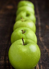 Green organic healthy apples on wooden board