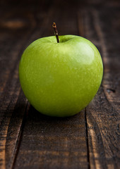 Green organic healthy apple on wooden board