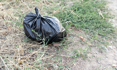 black bag of trash on the ground