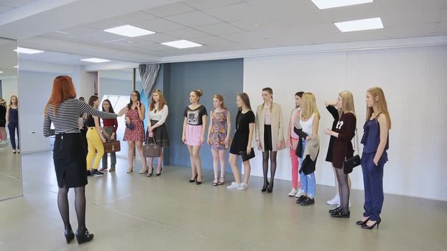 Young females are preparing for defile in model school.
