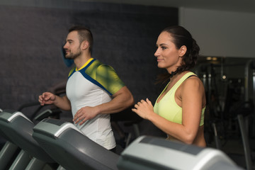 Fototapeta na wymiar Group Of People Running On Treadmills In Gym