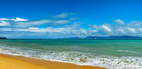 Sunny day with blue cloudy sky at tropical beach and sailboat on the horizon, Koh Samui, Thailand