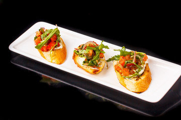 Bruschetta tomato, olive oil, arugula and cream cheese on a bagu