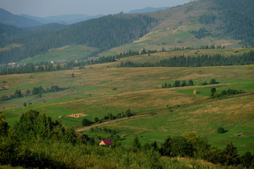 Fototapeta na wymiar Haystacks on beautiful summer plateau in Carpathian mountain. 