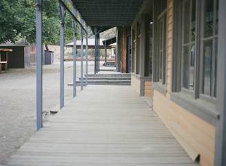 Dilapidated buildings from old west with wooden sidewalk and dirt street