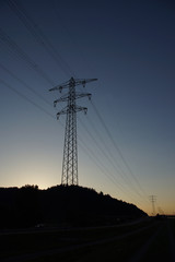 Überlandleitung entlang einer Straße, Abenddämmerung