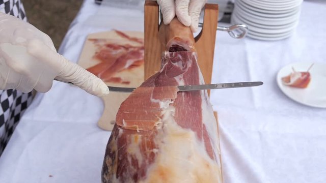 A front leg of Serrano ham mapped on a wooden stand with chef