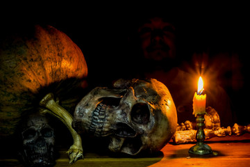 Fototapeta na wymiar Still Life with skull, candle, Pumpkin and faces man