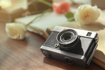 Vintage camera and beautiful roses on open photo album