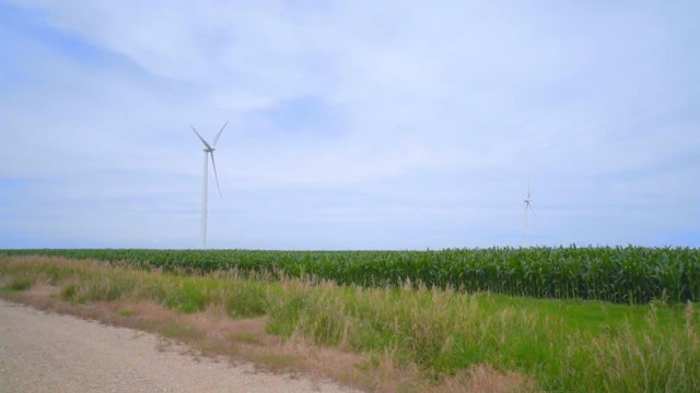 Wind turbines on green field over clouds sky. Alternative energy production. Wind turbines landscape. Renewable energy technology. Wind turbines farm. Wind turbine generator