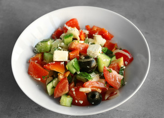 Plate with tasty salad on gray table